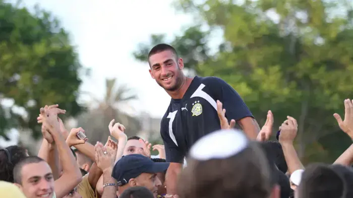 אלירן עטר שחקן מכבי תל אביב על כתפי אוהדים