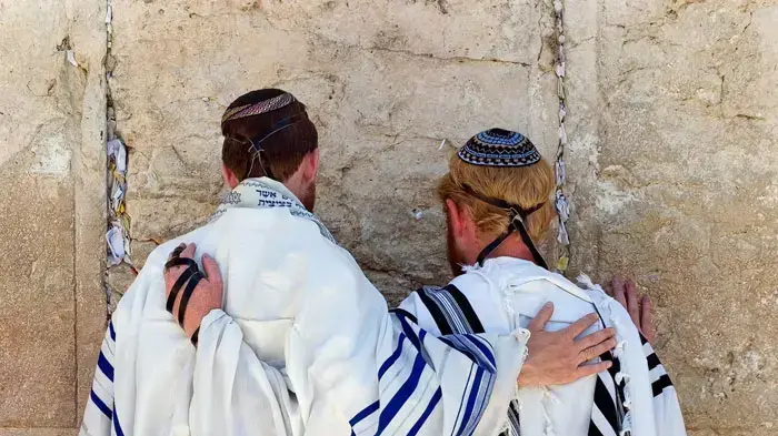 זוג גברים מתפללים בכותל