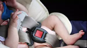 אישה נוהגת ובספסל האחורי ילד ישן