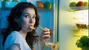 אישה אוכלת ליד המקרר