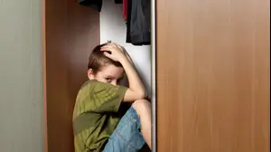 ילד עצוב מתחבא בארון