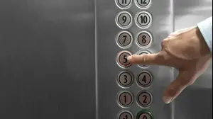 אדם לוחץ על כפתור במעלית