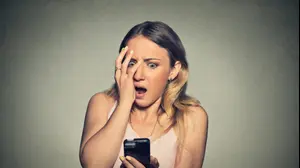 אשה מסתכלת בשוק בטלפון הנייד