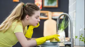 נערה מבואסת שוטפת כלים
