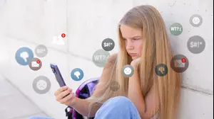 ילדה צעירה גולשת באינטרנט באמצעות הטלפון הנייד