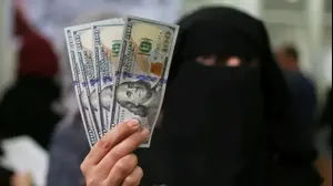 עובדת ברשויות של חמאס מציגה דולרים אחרי שקיבלה את המשכורת ששולמה על ידי קטאר ברצועת עזה, 7 בדצמבר 2018