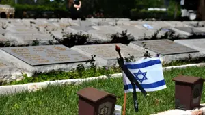 דגלי ישראל על קברי חיילים, לקראת טקס יום הזיכרון לחללי צה"ל, בית עלמין נחלת יצחק, 29 באפריל 2025