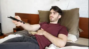 גבר צופה בטלוויזיה במיטה