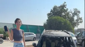 גילי לוי ברקאי לצד הרכב השרוף עם האייפון ביד