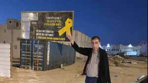 הישאם א-סייד ליד השלט לכבוד שובו, באוגוסט