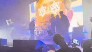 צלב קרס משולב במגן דוד על עיניו של בנימין נתניהו, כחלק מווידאו בהופעה של להקת פריימל סקרים בלונדון