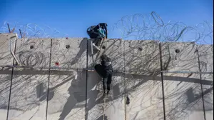 פלסטינים חוצים את גדר ההפרדה באמצעות חבל, סמוך לא-ראם, 23 בדצמבר 2025