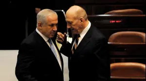 ראש הממשלה המיועד בנימין נתניהו משוחח עם ראש הממשלה היוצא אהוד אולמרט במהלך טקס ההשבעה של הקואליציה החדשה בראשות נתניהו בכנסת, 31 במרץ 2009