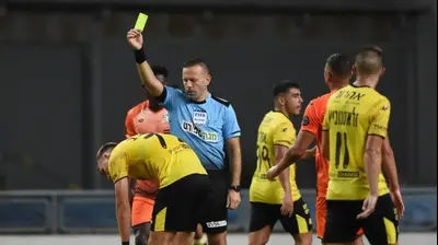 אוראל גרינפלד שולף כרטיס צהוב לעבר עדן קארצב שחקן מכבי נתניה. ברני ארדוב