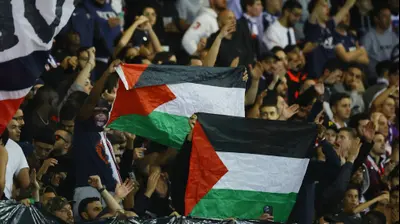 אוהדי פריז סן ז'רמן מניפים דגלי פלסטין נגד מכבי חיפה. רויטרס