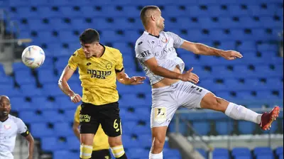 שחקן מכבי נתניה, עומרי גנדלמן, ליד עידו לוי, שחקן הפועל חדרה. ברני ארדוב