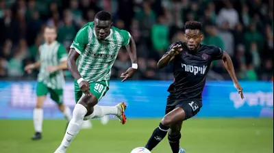 שחקן מכבי חיפה עבדולאי סק רודף אחרי שחקן הפועל באר שבע יוג'ין אנסה. מאור אלקסלסי