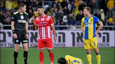 שחקן בני סכנין, בירם כיאל, ליד שחקן מכבי תל אביב, דור פרץ והשופט יגאל פריד. אריאל שלום