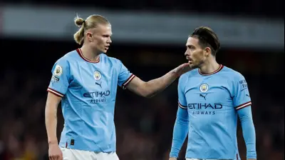 שחקן מנצ'סטר סיטי ארלינג הולאנד עם ג'ק גריליש. IAN KINGTON/IKIMAGES/AFP,GettyImages