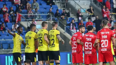 חומה של שחקני הפועל באר שבע לצד חומה של שחקני מכבי נתניה. ברני ארדוב