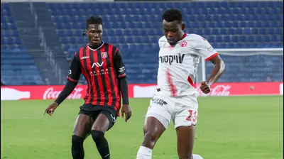 יוג'ין אנסה שחקן הפועל באר שבע לפני אלוז' יאו שחקן הפועל ירושלים. דני מרון