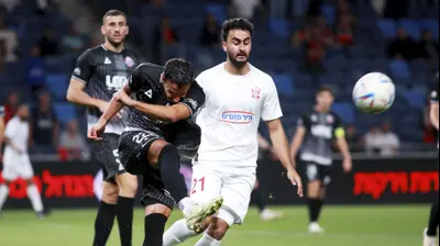 מוחמד עוואד שחקן בני סכנין מול גיא מזרחי שחקן הפועל חיפה. קובי אליהו