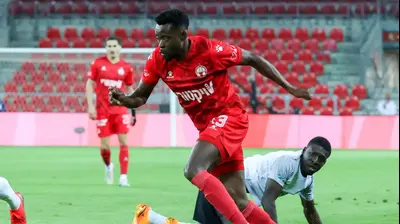 שחקן הפועל באר שבע יוג'ין אנסה, שחקן מכבי חיפה עלי מוחמד צופה בו. דני מרון