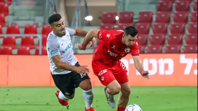 שחקן מכבי חיפה מוחמד אבו פאני ליד שחקן הפועל באר שבע אדריאן פאון. דני מרון