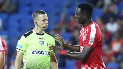 שחקן הפועל חדרה סולימאן קוליבאלי עם השופט אוהד אסולין. דני מרון