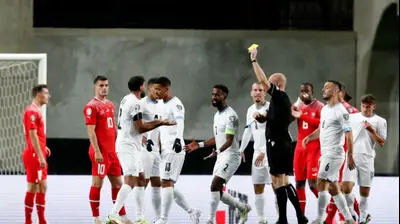אנתוני טיילור שופט אנגלי שולף כרטיס צהוב לעבר אופיר דוידזאדה שחקן נבחרת ישראל. רויטרס