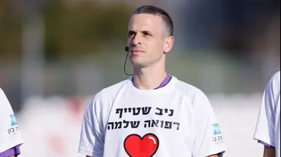 השופט אוהד אסולין עם חולצה ואיחולי החלמה לשופט ניב שטייף. מאור אלקסלסי