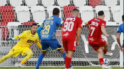 שחקן הפועל תל אביב, עומרי אלטמן, כובש בפנדל מול גד עמוס, שוער בני ריינה. מאור אלקסלסי