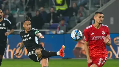 צ'ארון שרי שחקן מכבי חיפה בועט מול אור בלוריאן שחקן הפועל תל אביב. ברני ארדוב