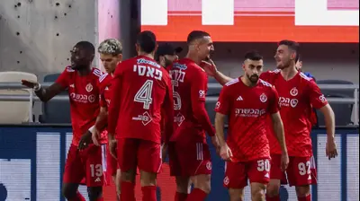 שחקני הפועל תל אביב חוגגים עם הישאם לאיוס. דני מרון