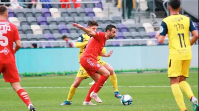 דן איינבינדר שחקן הפועל תל אביב לפני רועי שוקרני שחקן מכבי בני ריינה. קובי אליהו