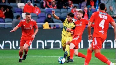 דויד קופרמן שחקן הפועל תל אביב עוצר את פרדי ורגאס שחקן מכבי בני ריינה. קובי אליהו