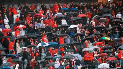 אוהדי הפועל תל אביב בגשם. קובי אליהו