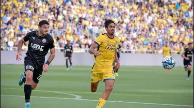 שחקן הפועל חיפה, ינון אליהו, ליד שחקן מכבי תל אביב דור פרץ. אריאל שלום