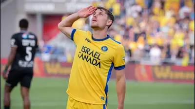 שחקן מכבי תל אביב, גבי קניקובסקי, מצדיע לזכר חבריו שנהרגו במלחמה, אחרי שכבש שער. אריאל שלום