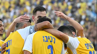 שחקני מכבי תל אביב חוגגים עם רוי רביבו. ברני ארדוב