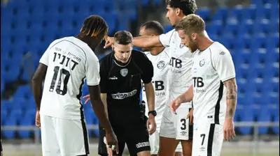 דקל צינו שופט כדורגל לצד שחקני הפועל חדרה. ברני ארדוב