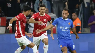 שחקן הפועל באר שבע דן ביטון ליד רביד אברג'יל שחקן מ.ס. אשדוד. דני מרון