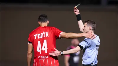 השופט דקל צינו שולף כרטיס צהוב לעבר חאתם עבד אלחמיד שחקן בני סכנין. מאור אלקסלסי