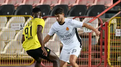 שחקן מכבי נתניה, הרי טבארש, מול שחקן מ.ס. אשדוד אורי עזו. ברני ארדוב