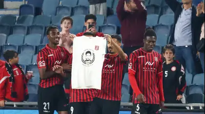 מתן חוזז שחקן הפועל ירושלים מציג חולצה לזכרו של הירש גולדברג-פולין הי