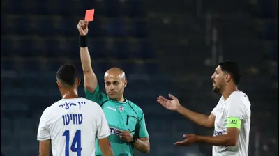 השופט נאאל עודה שולף כרטיס אדום לעבר דודי טויטו שחקן עירוני קרית שמונה, לצדו עאיד חבשי. דני מרון