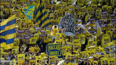 אוהדי מכבי תל אביב עם שלטים שקוראים לשחרור גלי וזיוי ברמן, ושאר החטופים. שירה קז