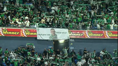 אוהדי מכבי חיפה עם שלט למען החטוף מתן אנגרסט. ברני ארדוב