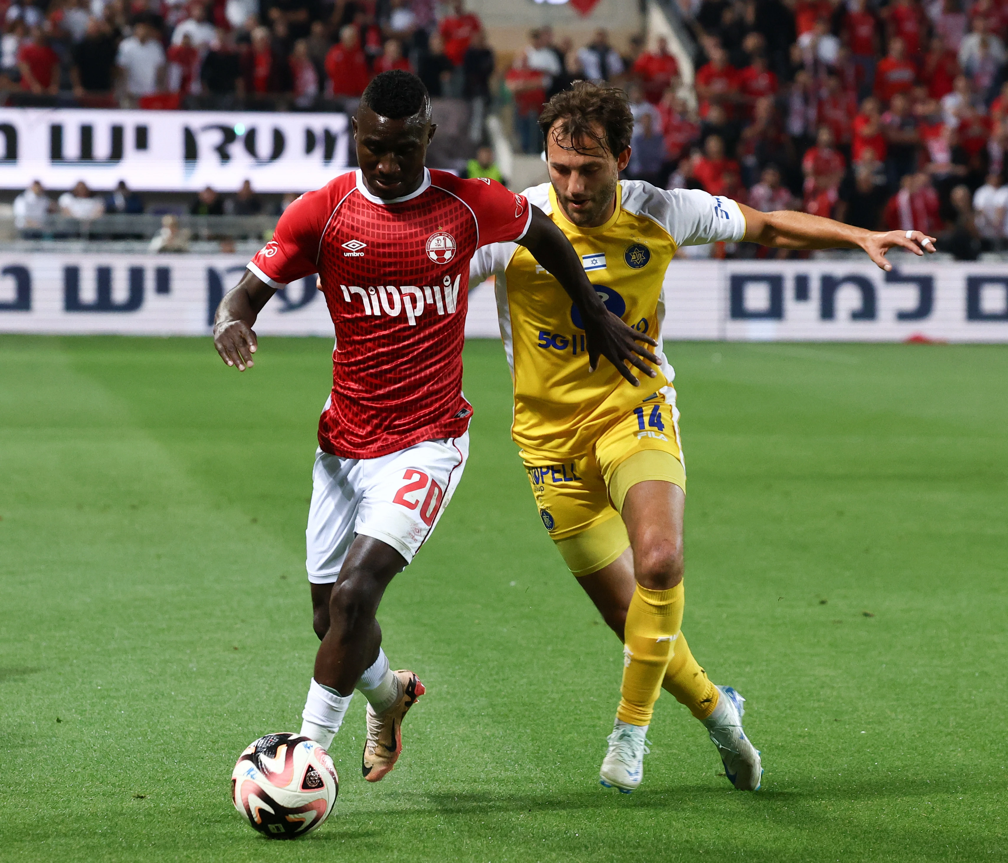 שחקן מכבי תל אביב יוריס ואן אובריים, מול שחקן הפועל באר שבע קינגס קאנגווה. דני מרון