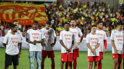 שחקני מ.ס. אשדוד עם חולצות למען גדי קינדה. לירון מולדובן 